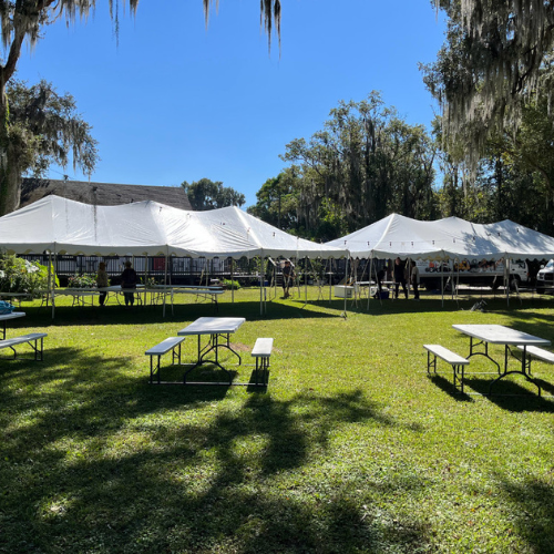 A landscaped property set up with event tables and tents.