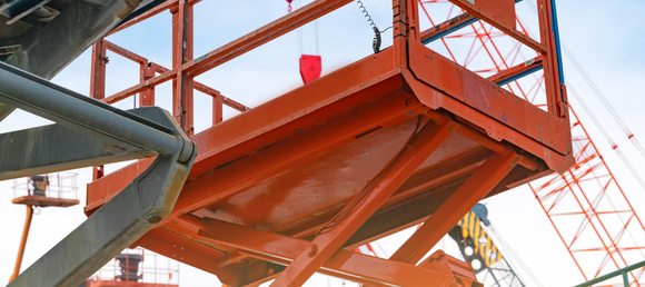 A close up of an orange boom lift.