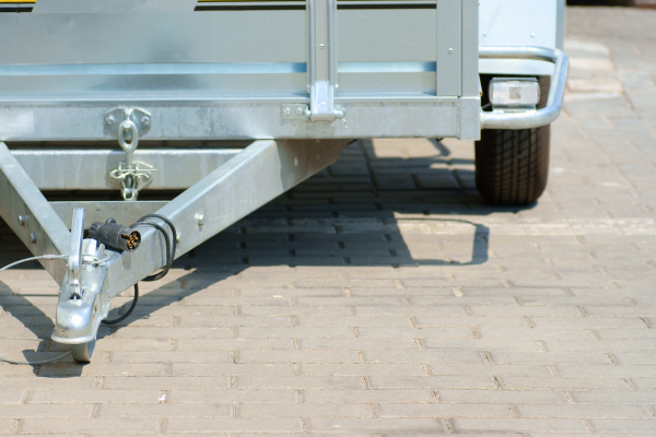A close up of tow bars underneath a small trailer.